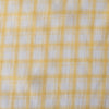 Subtle and soft Sunny Check linen fabric with lemon and white checks, offering a fine weave and gentle drape for elegant apparel.