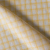Subtle and soft Sunny Check linen fabric with lemon and white checks, offering a fine weave and gentle drape for elegant apparel.