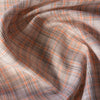 Earthy plaid linen fabric with vivid pumpkin threads and natural texture, suitable for creating comfortable and stylish wardrobe staples.