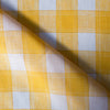 Happy yellow check Popcorn 100% linen fabric with natural slubs and fine brown thread, ideal for creating smooth and finely woven garments.