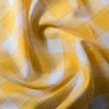 Happy yellow check Popcorn 100% linen fabric with natural slubs and fine brown thread, ideal for creating smooth and finely woven garments.