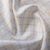 Creamy Lemon Oatmeal Check Linen Fabric, featuring sunshine yellow and earthy checks on white linen, with a fine weave for a soft feel and elegant drape.