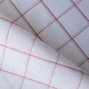 Harmony Checks Linen Blend Fabric. A lightweight linen-cotton blend fabric with a plaid pattern of thin red stripes forming a grid on a light beige background, indicating a composition of 52% linen and 48% cotton and a weight of 135 GSM.A lightweight linen-cotton blend fabric with a plaid pattern of thin red stripes forming a grid on a light beige background, indicating a composition of 52% linen and 48% cotton and a weight of 135 GSM