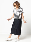 Lady wearing a black and white striped shirt made with the Blaire Shirt Sewing Pattern – Square-shaped with rolled cuffs and overlay.