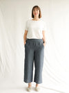 front view of lady wearing blue stripped linen pant made using Fifi Woven Pant sewing pattern, featuring a wide leg design with a smooth front yoke, elastic back, and side pockets, perfect for crepe, linen, and rayon fabrics.