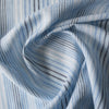 Vintage-style Blue Multi Stripe 100% Linen Fabric with varying stripes in navy, blue, and white on a light blue background, offering a washed-out look.