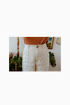 Lady wearing natural colour linen pants made of Bottlebrush Pants and Shorts Sewing Pattern - High-Waisted Flared Pants and Mini Shorts