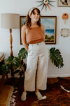 Lady wearing natural colour linen pants made of Bottlebrush Pants and Shorts Sewing Pattern - High-Waisted Flared Pants and Mini Shorts