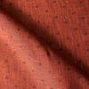 Close-up of burnt orange linen fabric with chocolate damask-style floral print and textured slubby yarn-dyed fibers