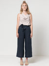 Clare Pant Sewing Pattern with wide leg, elastic waist, tie belt, angled pockets, and front pleats, perfect for fabrics like linen, crepe, or fine wool