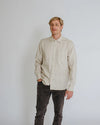 a man weariing off white colour shirt made using Finch Men's Shirt Sewing Pattern - Button-Up Shirt with Scoop Back Hem