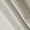 Honeydew Petals linen-cotton blend fabric with mustard floral print on a greyish-white base.