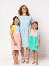 Lacey Kids Dress sewing pattern, featuring an easy slip-on design with extended shoulders, square line bodice, and slightly gathered skirt, suitable for knit or woven fabrics.