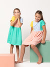 Lacey Kids Dress sewing pattern, featuring an easy slip-on design with extended shoulders, square line bodice, and slightly gathered skirt, suitable for knit or woven fabrics.