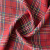 Close-up of Outback Tartan Linen fabric showcasing a vibrant red, green, blue, and yellow plaid pattern, suitable for sewing garments and home textiles.