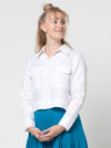 lady wearing white jacket made using Smith Woven Jacket with buttoned fly front, square shape, full-length sleeves with tabs, front pockets, and back pleat, made from linen fabric.