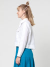 lady wearing white jacket made using Smith Woven Jacket with buttoned fly front, square shape, full-length sleeves with tabs, front pockets, and back pleat, made from linen fabric.