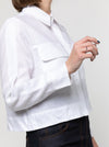 lady wearing white jacket made using Smith Woven Jacket with buttoned fly front, square shape, full-length sleeves with tabs, front pockets, and back pleat, made from linen fabric.