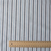 Alternating sky blue and midnight vertical stripes on a white linen blend fabric, with a natural slub texture and soft appearance.